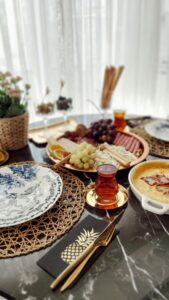 A beautifully set table with Turkish tea, fruit, and elegant dishware on a marble surface.