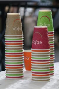 Vibrant stacked disposable coffee cups in a café setting, perfect for beverage themes.