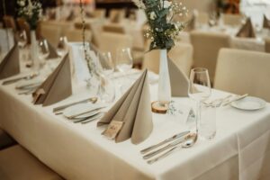 Beautifully decorated table setup for a formal dining event with flowers, silverware, and glassware.